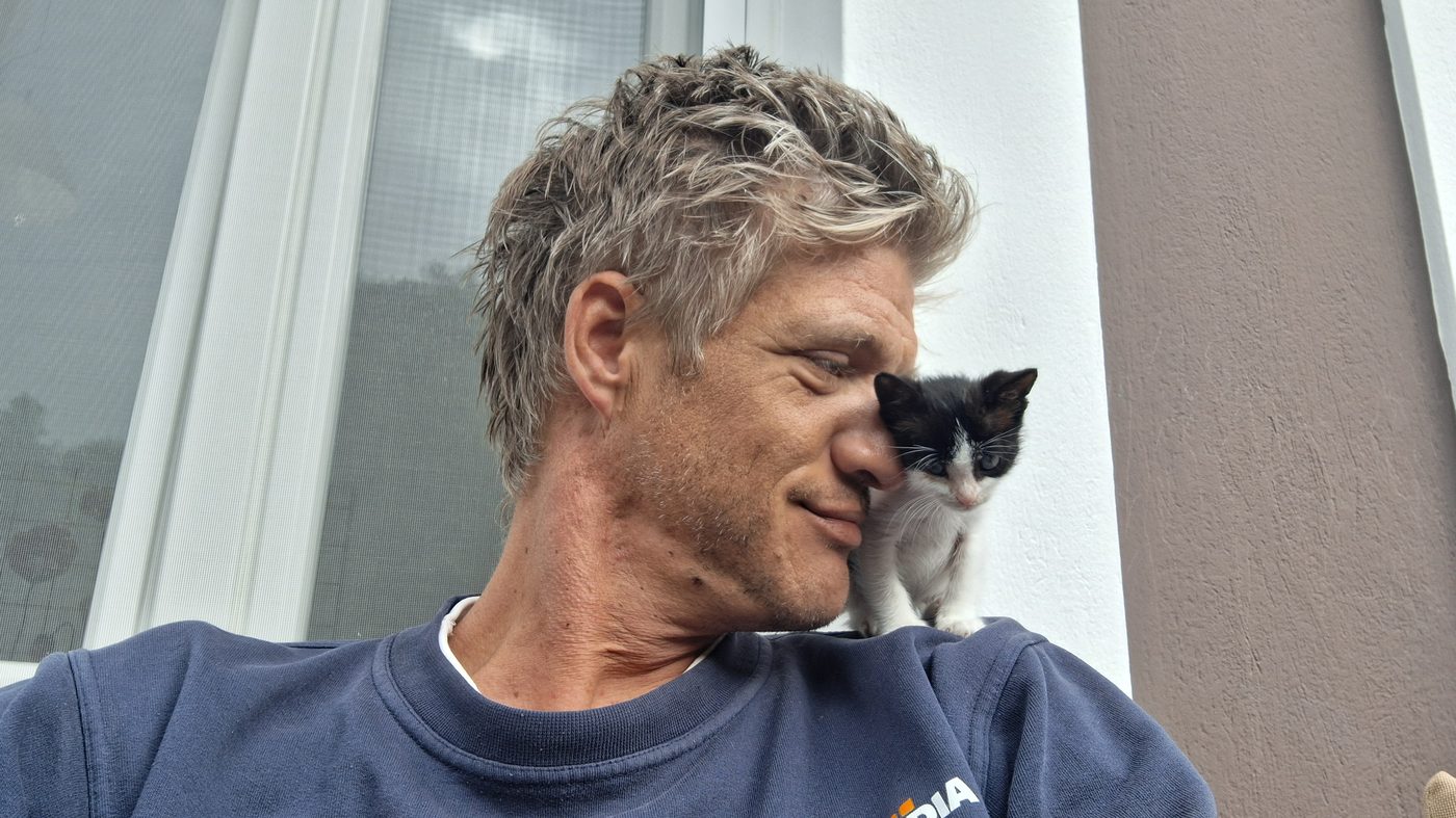 Asher as a newborn kitten, resting on Karel's shoulder