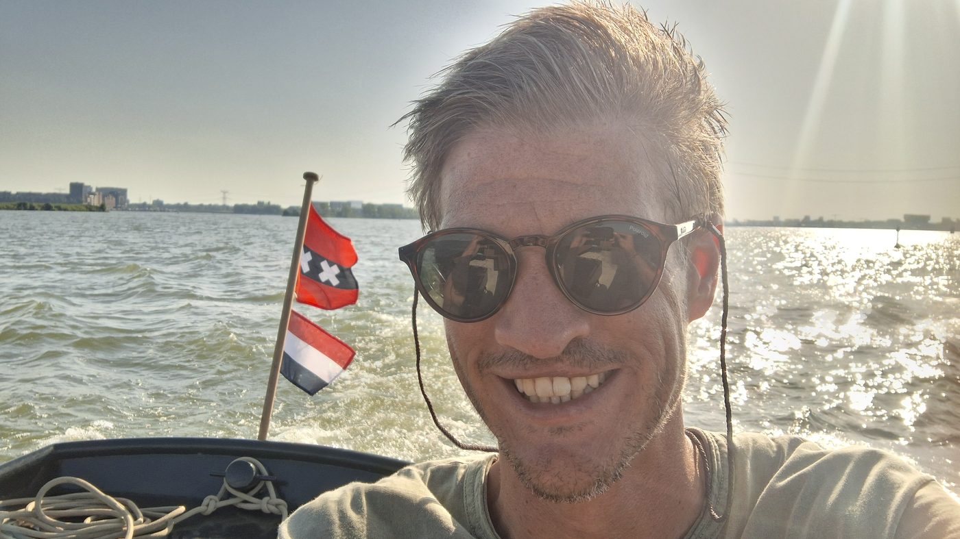 Karel on a boat on the water, smiling