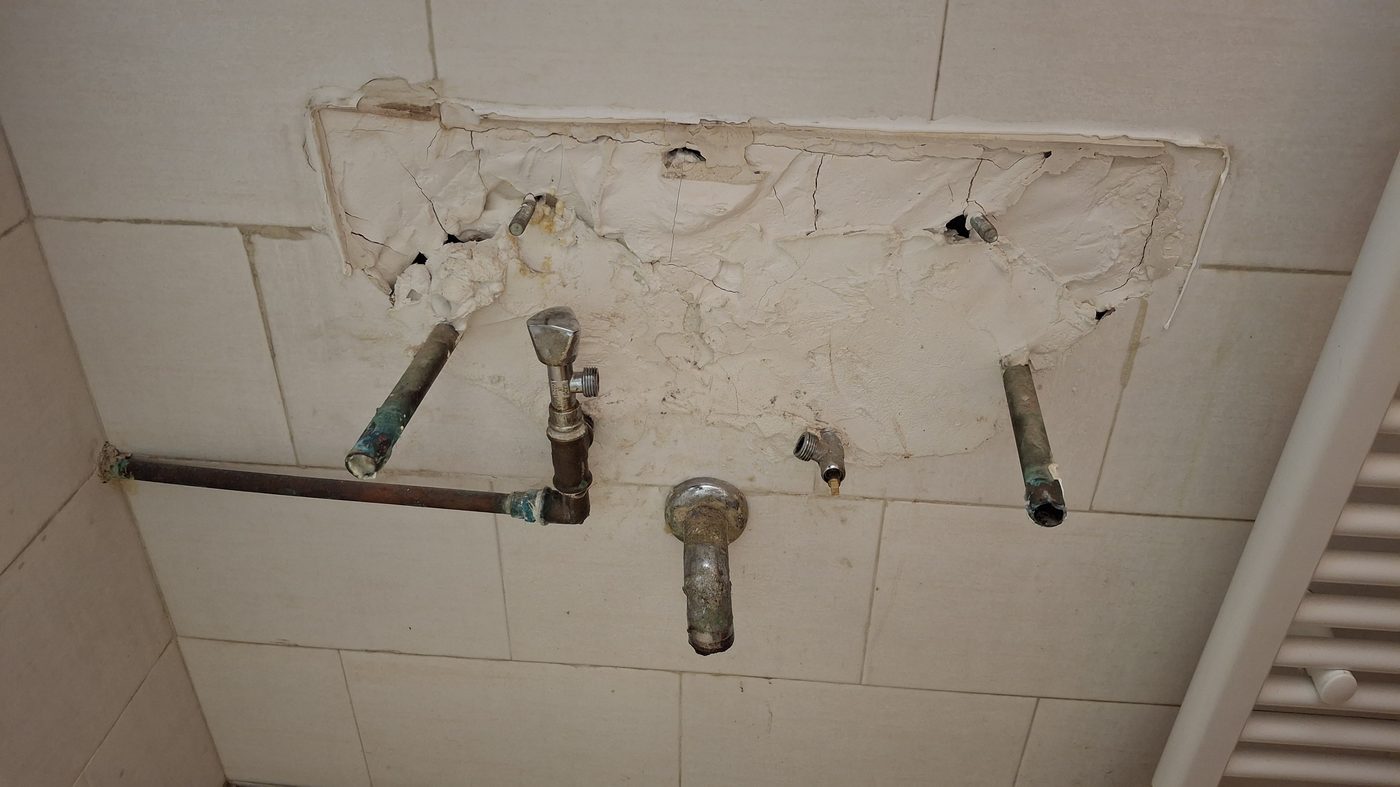 Exposed plumbing pipes during a bathroom repair
