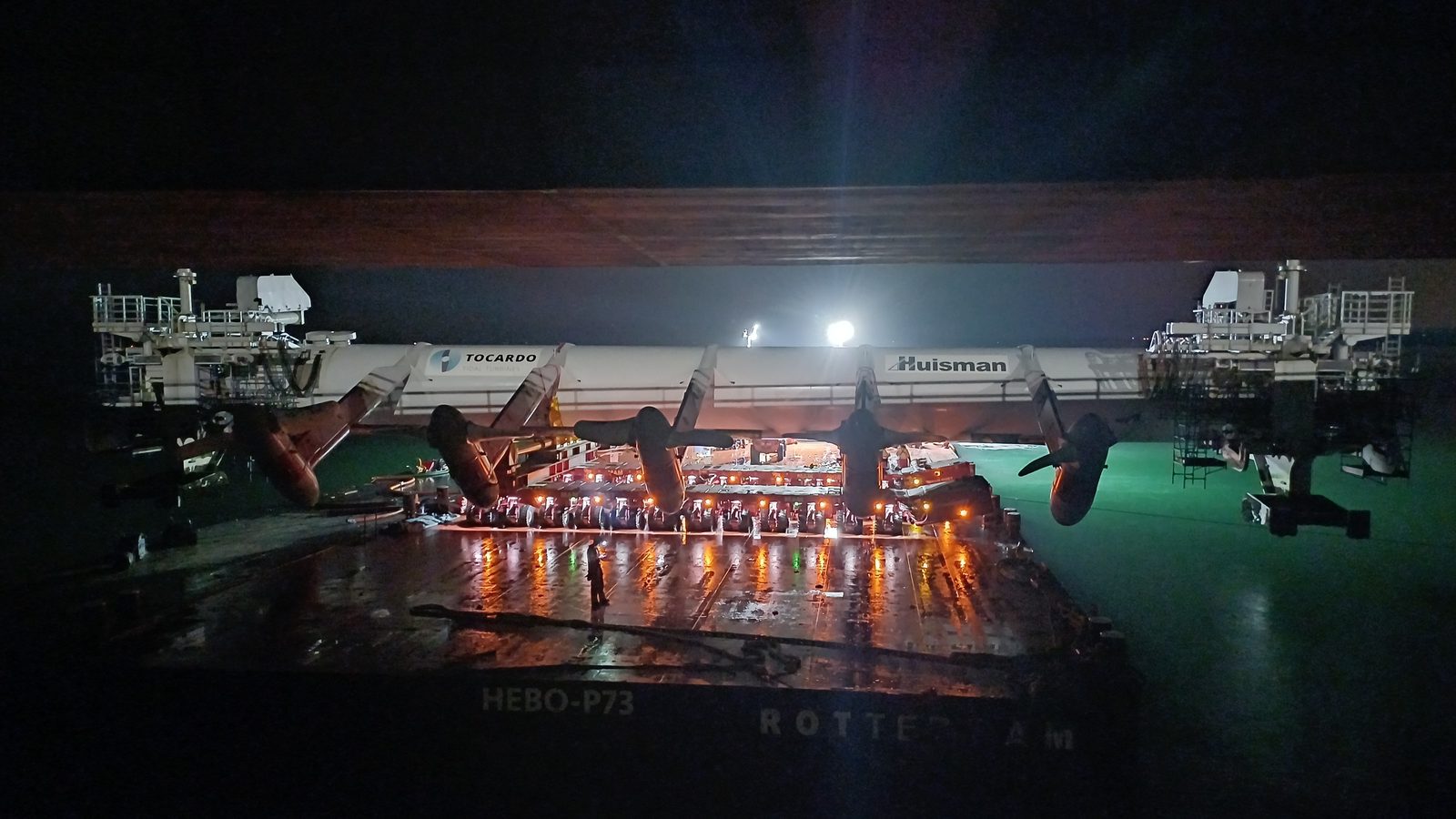 Heavy-lift transport of large turbine equipment at night on a barge