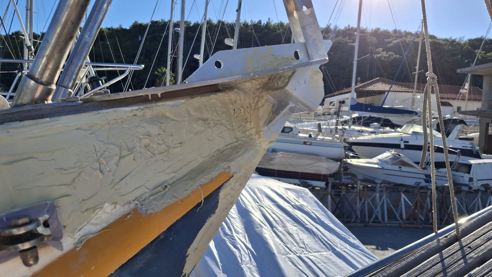 Hull fairing work at the bow of a sailboat