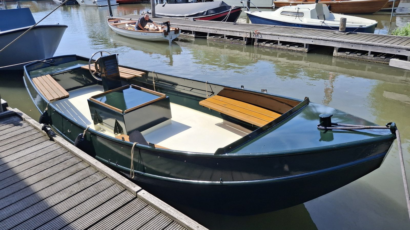 Restored open tender boat finished and moored at a dock